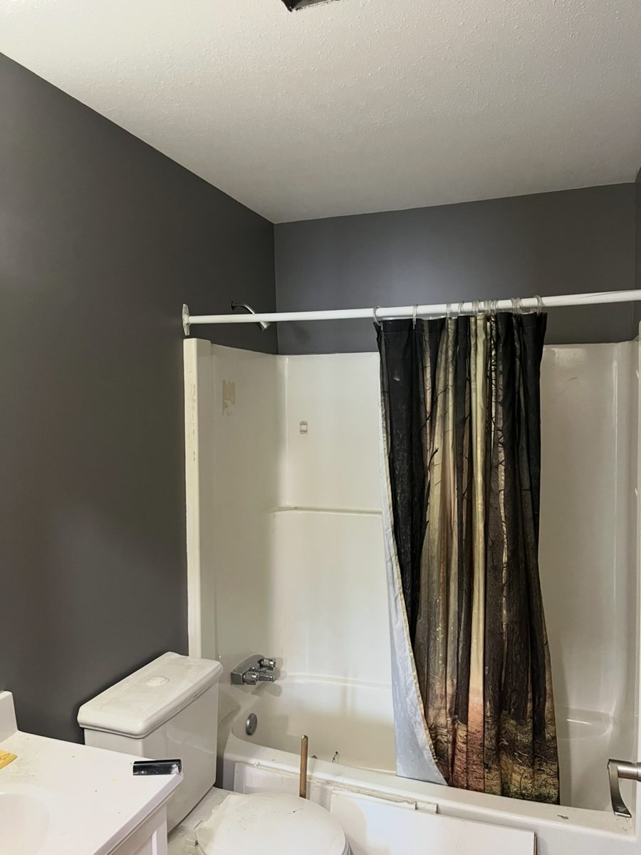 The same bathroom finished in charcoal grey with a clean white ceiling line