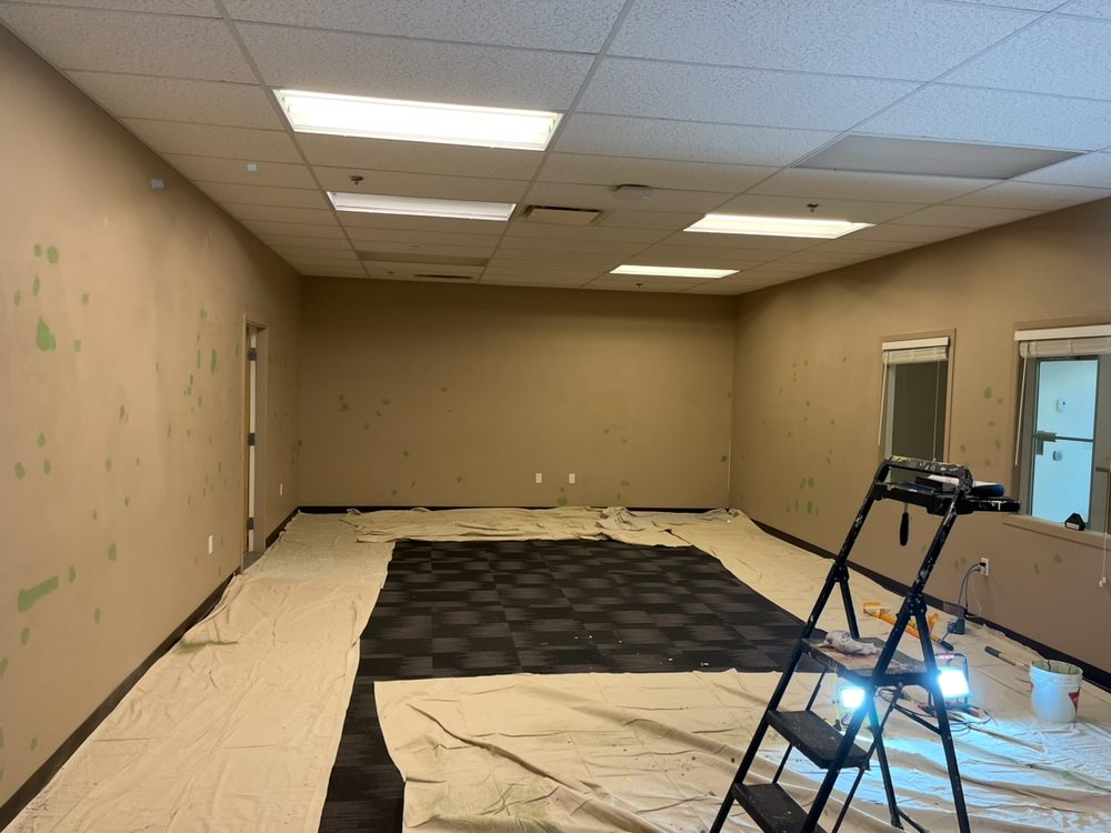 Open office area with filler patches, drop sheets down, prepped for repainting