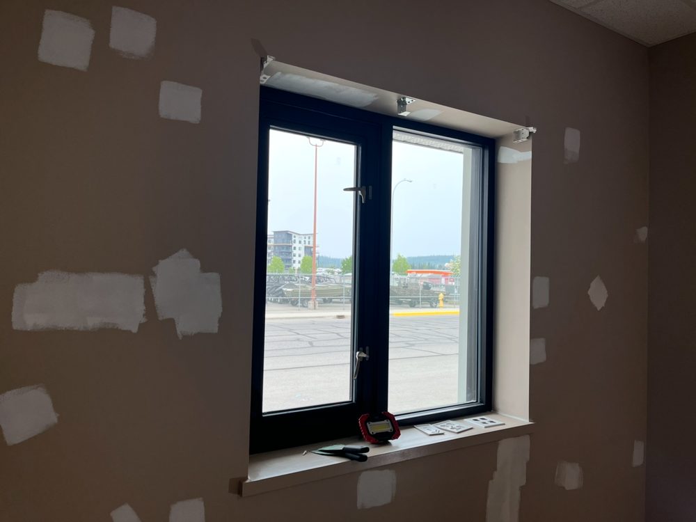 Filler patches sanded flush across an office wall before painting